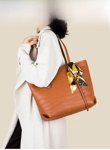 Brown faux leather tote bag with crocodile texture and silk scarf detail on handle