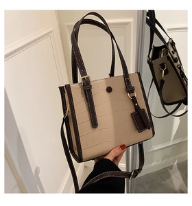 Detail of stone embossed pattern with contrast stitching on elegant tote shoulder bag