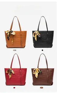 Detail of crocodile embossed tote bag with metal ring and printed silk scarf accessory