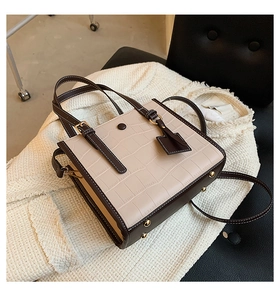 Detail of stone pattern tote bag with gold protective feet and contrasting trim