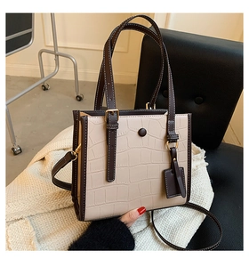 Detail of stone embossed tote bag with contrast beige and brown crocodile texture leather