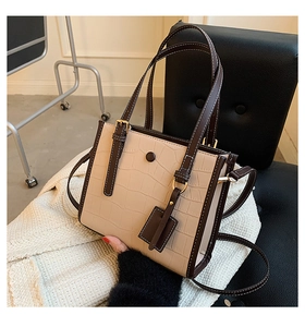 Detail of vintage crocodile embossed tote bag with brown trim and rivet accents