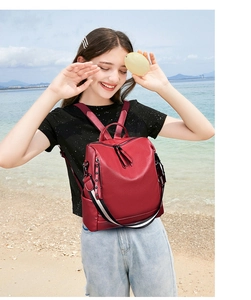 Zaino in pelle rossa martellata con tracolla a righe in ambiente spiaggia