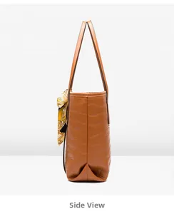 Side view of brown crocodile embossed tote bag featuring a decorative patterned silk scarf