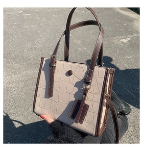Detail of stone pattern texture on the beige tote bag with contrasting brown straps