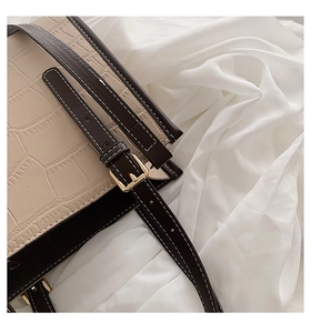 Close-up of stone pattern embossed leather texture with brown contrast strap detail