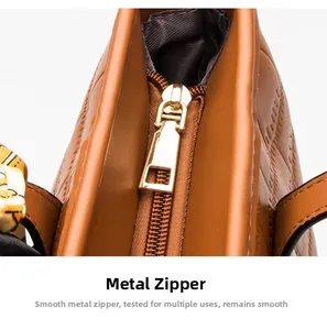 Close-up of golden metal zipper on brown quilted leather tote bag with silk scarf detail