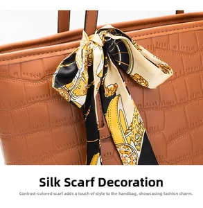 Detailed close-up of brown crocodile embossed leather handbag with chic decorative silk scarf