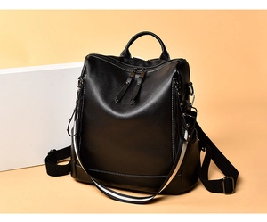Dettaglio dello zaino in pelle nera martellata con tracolla bicolore alla moda