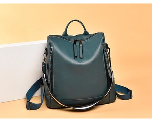 Dettaglio dello zaino in pelle PU verde scuro con cerniere laterali e texture martellata
