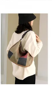 Detail of color-block canvas hobo bag showing retro patchwork texture and leather strap