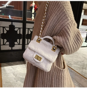 Détail d'un sac à main en peluche blanche avec fermoir doré et bandoulière en chaîne