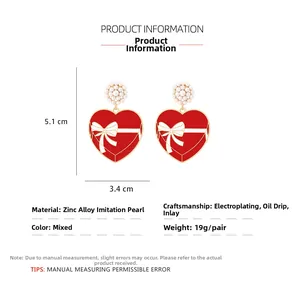 Detail view of heart drop earrings with dimensions of 5.1cm length and 3.4cm width