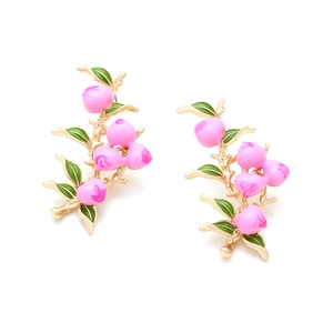 Detail of peach branch earrings with pink enamel fruit and green leaves on gold base