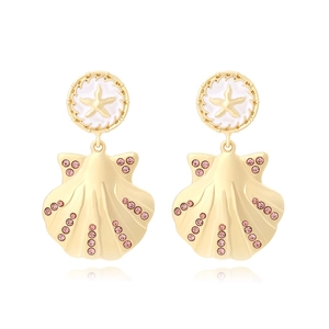 Détail de boucles d'oreilles étoile de mer dorées avec pendentifs coquillages et strass roses
