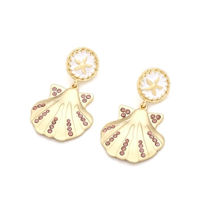Vue détaillée des boucles d'oreilles coquillage dorées avec cristaux roses