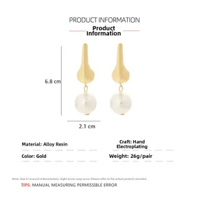 Detailed view of large pearl drop earrings with 6.8cm height and golden alloy finish