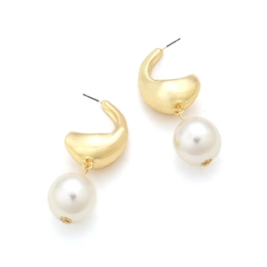 Close-up of golden teardrop metal earrings with large white pearls and floral caps