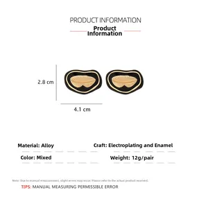 Détails de boucles d'oreilles cœur en émail noir avec motifs de feuilles dorées et poids