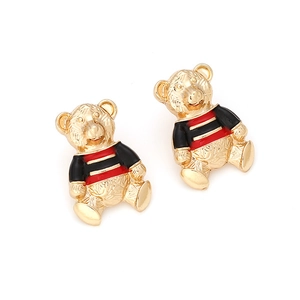 Vue macro de boucles d'oreilles ours en alliage doré avec émail rouge et noir