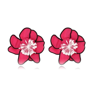 Détail de boucles d'oreilles fleurs en tissu faites main avec pétales roses et bord noir