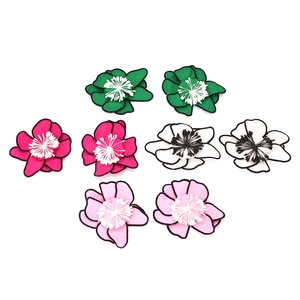 Détail de boucles d'oreilles fleurs en tissu multicouche avec bordures noires en couleurs