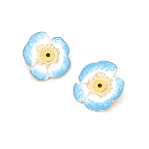 Détail de boucles d'oreilles fleurs en émail bleu clair avec bords dorés et effet marbré