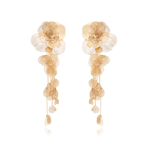 Boucles d'oreilles fleurs en filigrane doré avec de longs glands sur fond blanc