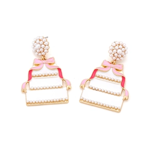 Detail of three-tier cake drop earrings with white enamel, pearls and pink bow ribbons