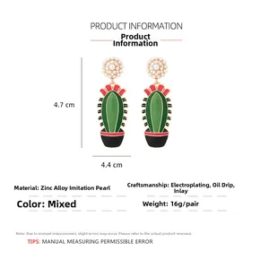 Détail des boucles d'oreilles cactus avec perles d'imitation et émail vert sur fond blanc