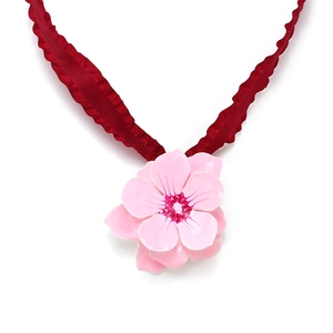 Detail of pink enamel flower pendant with pleated red ribbon necklace for women