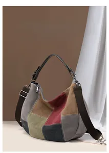 Close-up of color-block canvas tote bag featuring premium leather handles and wide strap