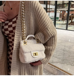 Détail d'un mini sac bandoulière en peluche blanche avec chaîne dorée et texture douce