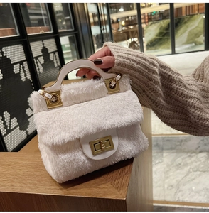 Détail du sac à main blanc en peluche avec fermoir doré et poignée rigide en forme de U