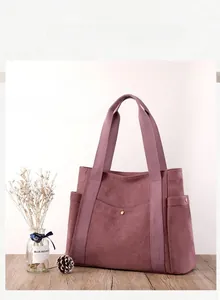 Dettaglio della borsa in tela viola scuro con fibbia in metallo su superficie in legno