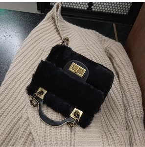 Détail du sac à main noir en fausse fourrure avec fermoir tournant doré et bandoulière