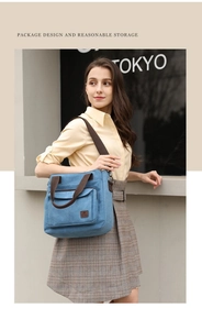 Detail of blue canvas tote bag featuring contrast brown straps and large front pocket