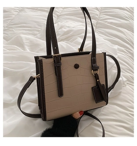 Detail of stone embossed pattern tote bag with beige and brown leather texture