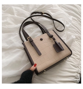 Detail of stone embossed pattern tote bag with vintage buckle and brown straps