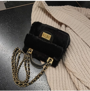 Détail du sac à bandoulière en peluche noire avec fermoir doré et bandoulière chaîne