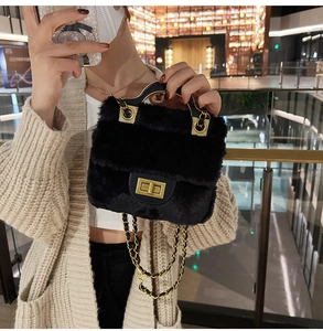Détail d'un sac à main en peluche noire avec bandoulière dorée et poignée en métal