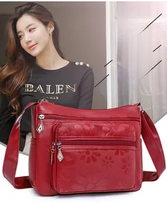 Détails du sac à bandoulière en similicuir rouge foncé avec fleurs gaufrées et zips