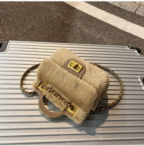 Détail du sac à main en peluche avec poignée en métal doré et fermoir rotatif carré