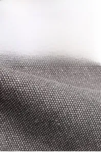 Dettaglio del tessuto in tela grigio scuro con trama spessa e materiale morbido e resistente