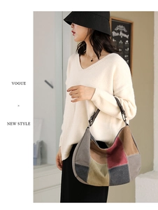 Detail of color-block patchwork canvas hobo bag with leather strap on a model
