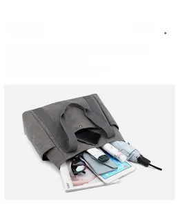 Dettaglio della borsa in tela grigio scuro con tasche multiple e interno molto capiente