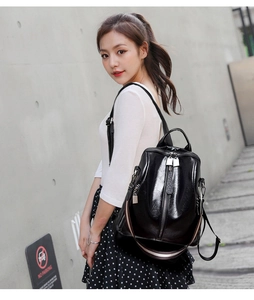Fashionable black faux leather backpack with vertical silver zipper and striped web detail