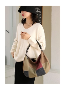 Detailed view of color-block canvas hobo bag with adjustable leather shoulder strap on model