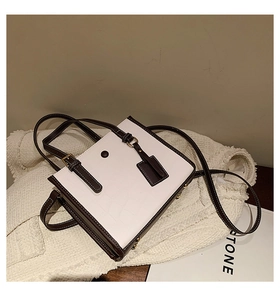 Detailed view of crocodile embossed leather tote with metal feet on knit fabric