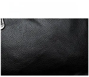 Close-up of black litchi grain leather fabric with a silver metal zipper head detail